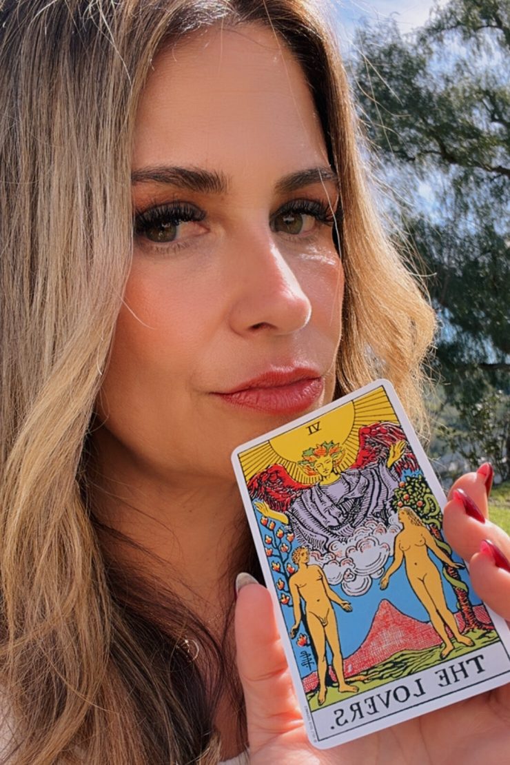 Stephanie holding The Lovers tarot card